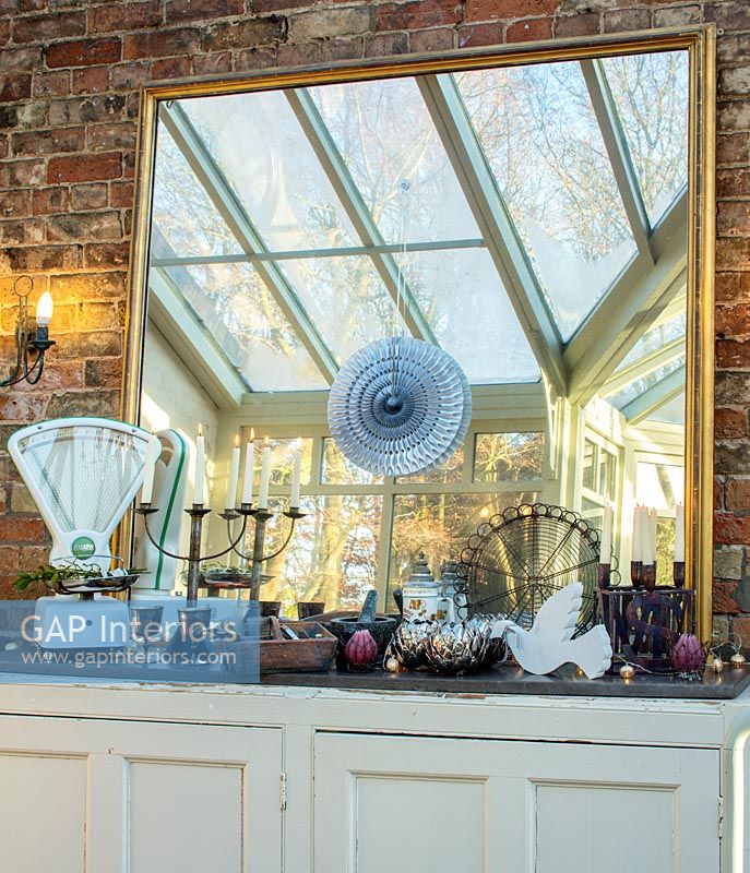 Vintage items on sideboard with mirror in classic conservatory 