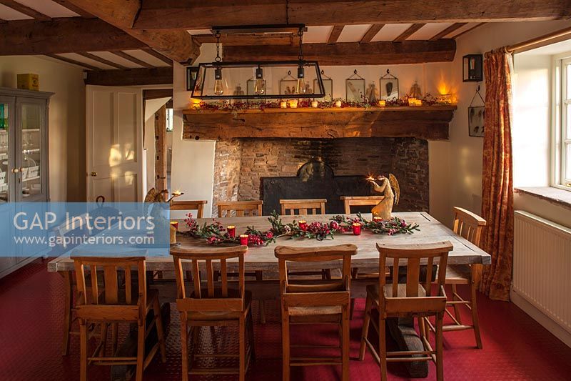 Country dining room with large fireplace - Christmas garland on table 