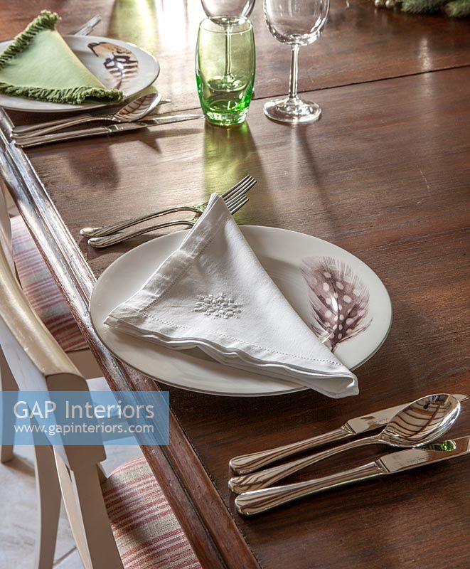 Feather plate, silverware on classic dining table 
