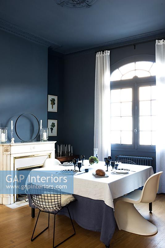 Dark blue dining room with white furnishings 