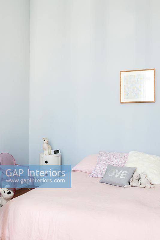 Pale blue walls and pink bedding in childrens room 