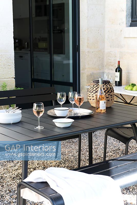 Black dining table on gravel terrace 