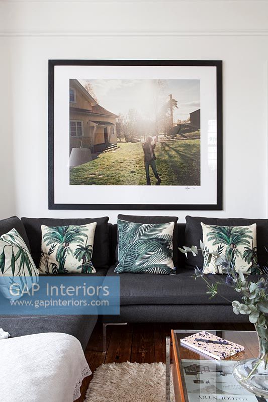 Large framed photograph over black sofa 