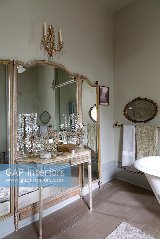 Large mirror and marble console table in classic bathroom 