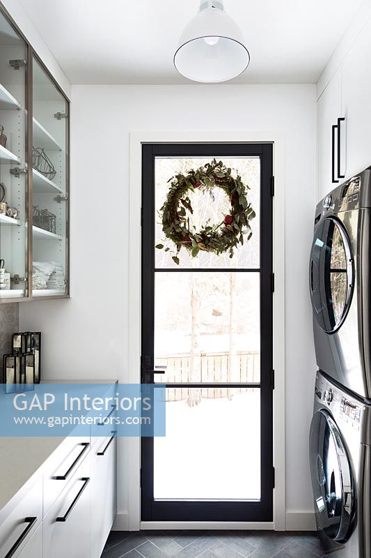 Christmas wreath on black framed glass door in modern kitchen 