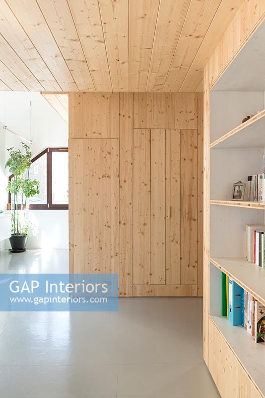 Wooden feature wall with concealed door and built-in bookcase