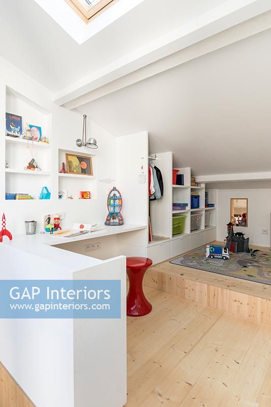 Modern childrens room with built-in shelving and open wardrobe 