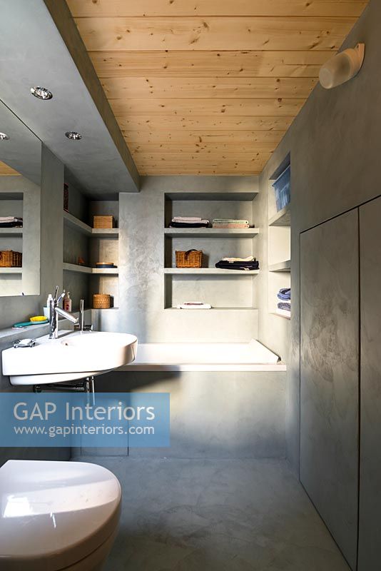 Modern concrete bathroom with wooden ceiling 