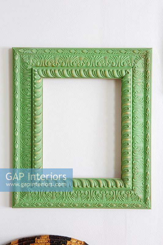 Green painted wooden picture frame on wall 