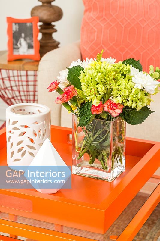 Flower arrangement on bright orange table 