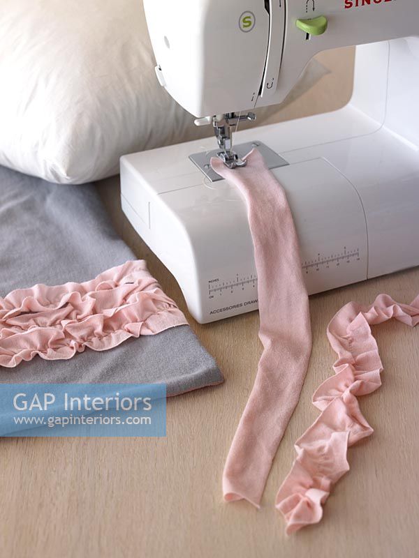 Strips of pink fabric and sewing machine