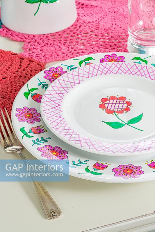 Painted plates with folk art motifs on dining table 