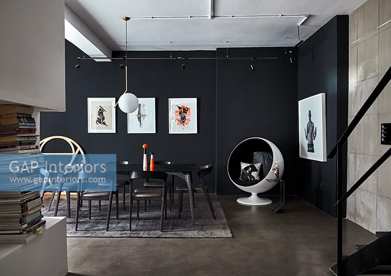 Modern dining room with black painted wall and concrete floor 