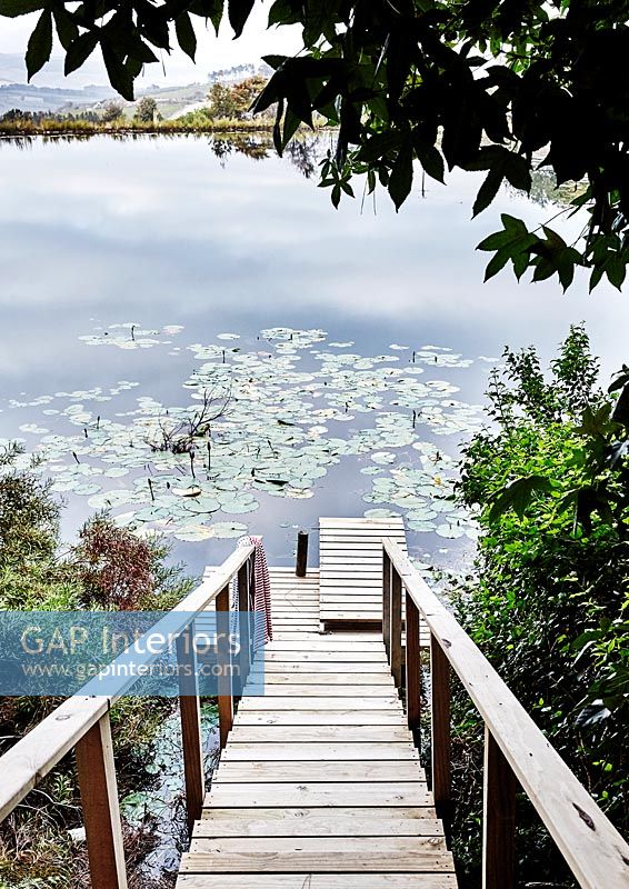 Timber staircase leading to small jetty and lake 