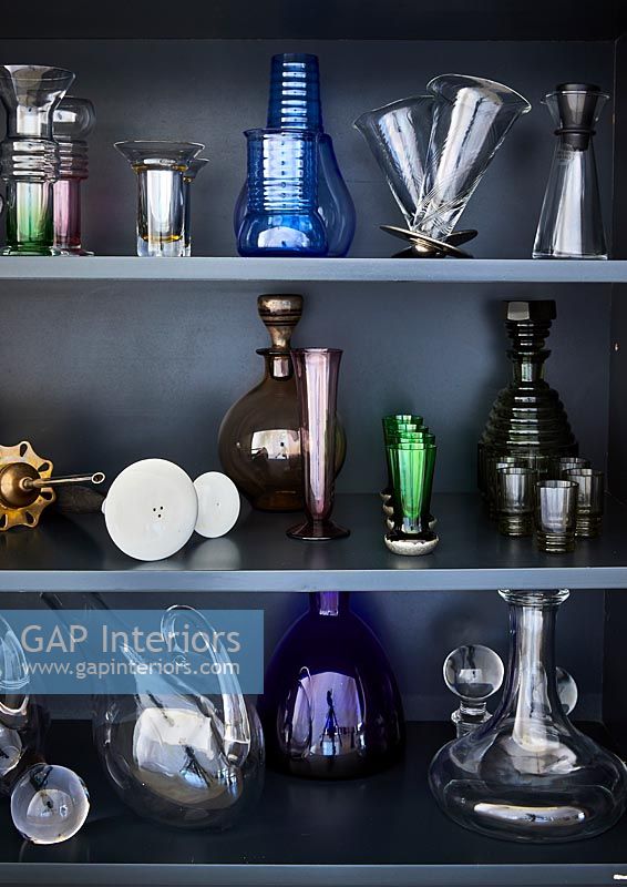 Display of glassware on grey shelves 