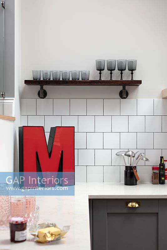 Large red letter 'M' on modern kitchen worktop 