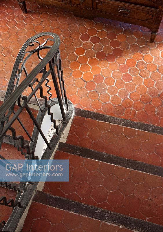 Hexagon terracotta floor tiles on classic staircase 
