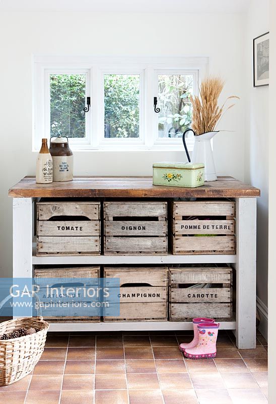 Old vegetable crates used as drawers in country hallway 