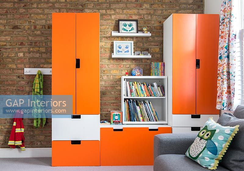 Orange wardrobe unit in modern childrens bedroom 