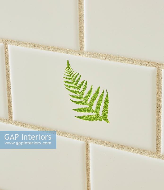 Detail of decorative kitchen tile with image of fern 