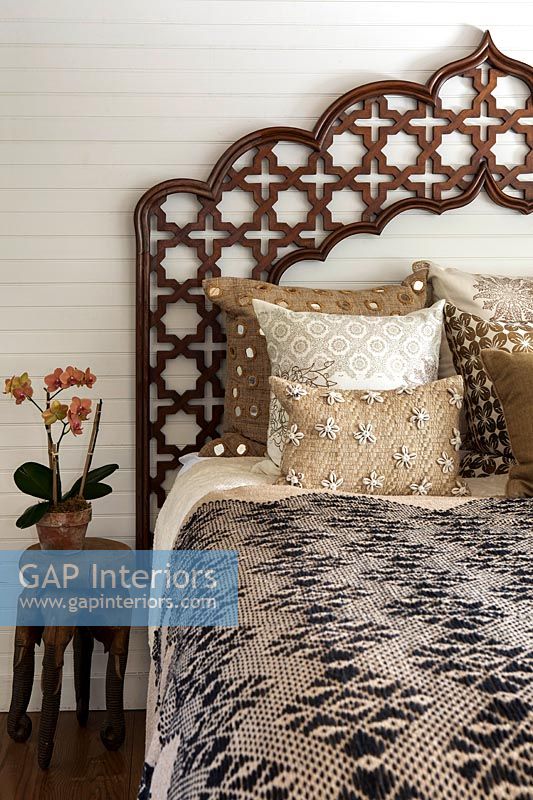 Decorative carved wooden headboard on bed 