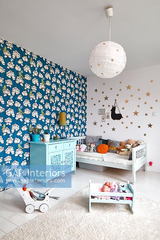 Childrens room with bold print wallpaper on feature wall 