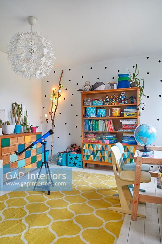 Colourful playroom with spotty feature wall and decorative lights 