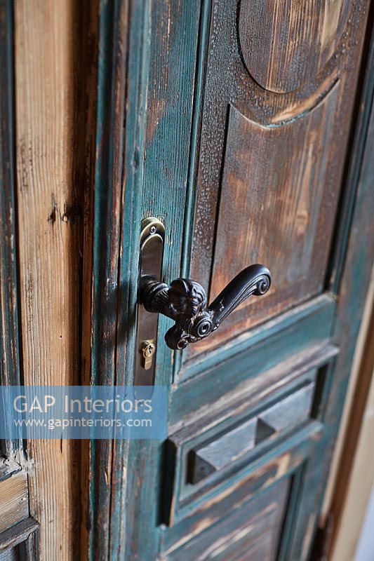Distressed painted door with classic iron door handle 