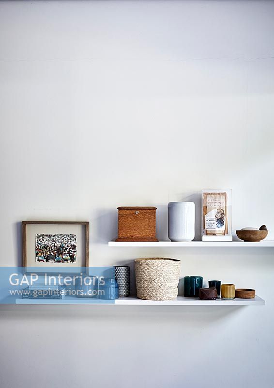 Ceramic pots and other ornaments on white shelves 