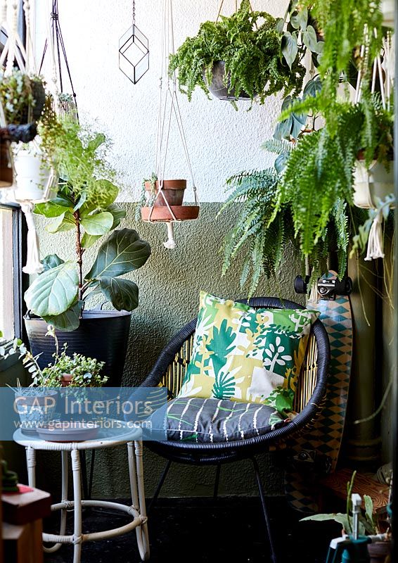 Garden furniture on terrace with plants in containers 