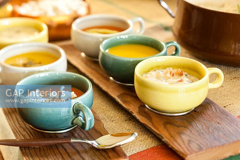 Soup in bowls on wooden trays 