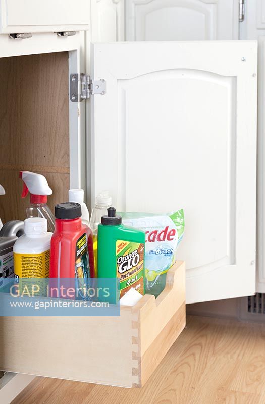 Kitchen cupboard with pull out drawer for cleaning products 