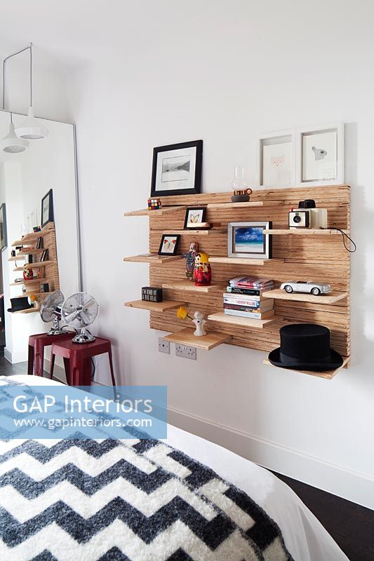 Wooden wall mounted shelving unit on bedroom wall 