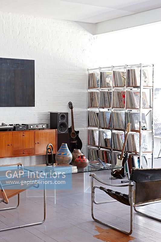 Vinyl records on shelves in room with musical instruments 