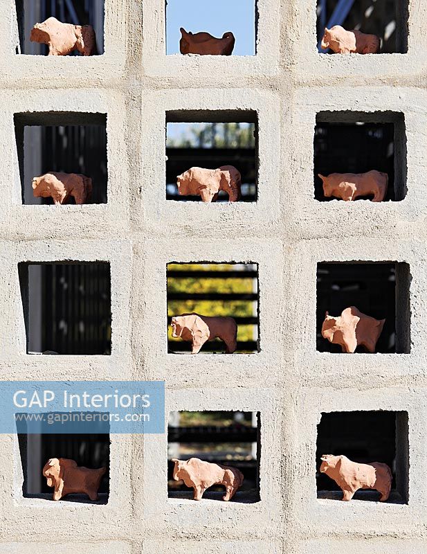 Display of ceramic bulls in gaps in breezeblock wall 