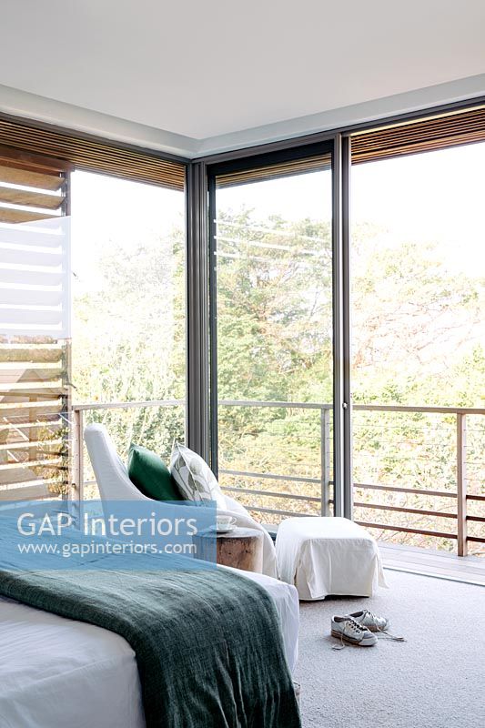 Modern bedroom with patio doors and view of tree tops 