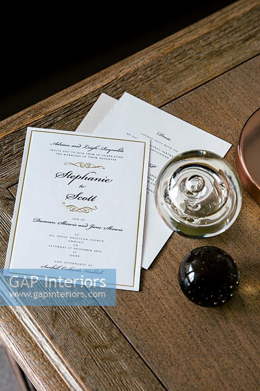 Invitations and paperweight on desk 