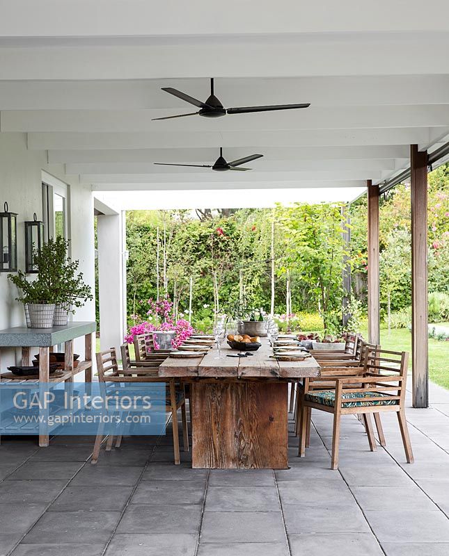 Covered terrace with large wooden dining area 