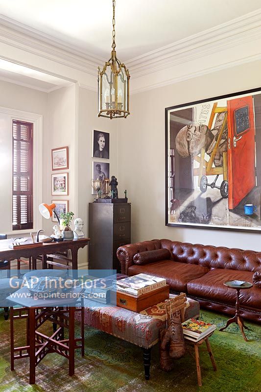 Vintage leather sofa and modern art in living room 