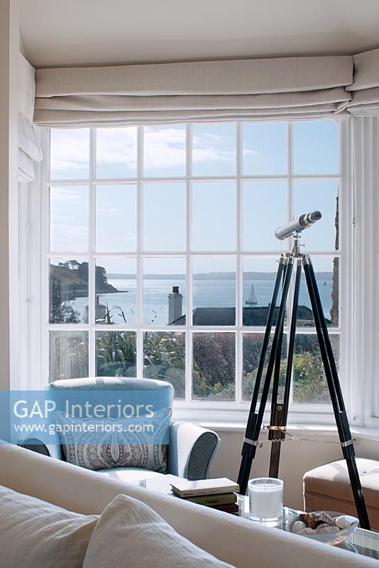 Telescope next to window with sea view 