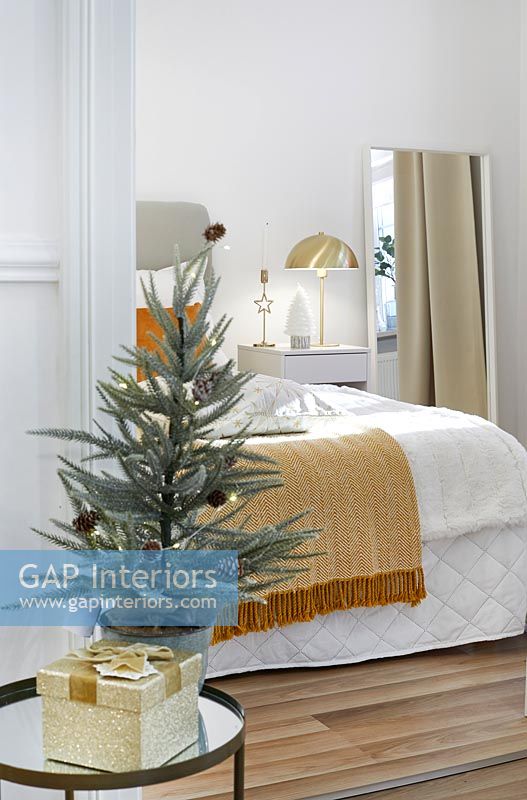 View into modern bedroom with side table decorated for Christmas 