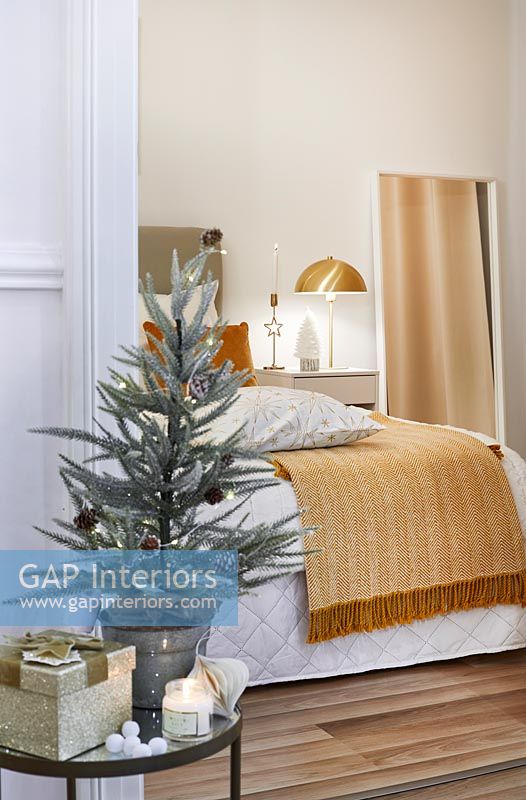 View into modern bedroom with side table decorated for Christmas 