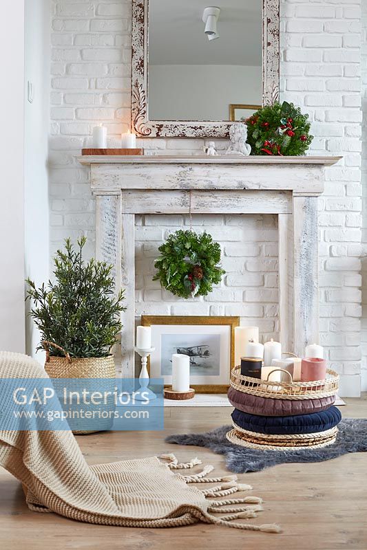 Tray of candles and wreath on mantelpiece in modern country living room at Christmas 