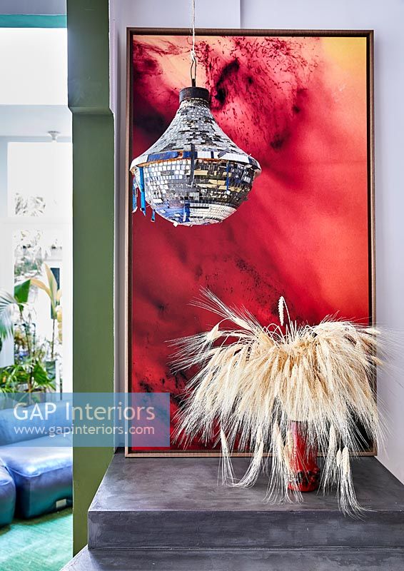Decorative chandelier in front of large red painting 