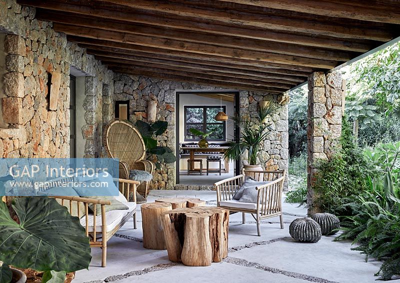 Porch of stone country house with outdoor living area 
