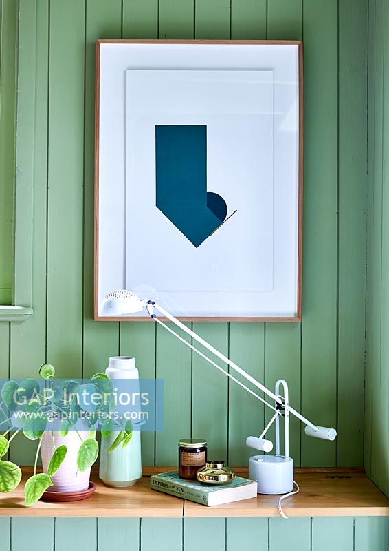Framed painting on green wooden wall 