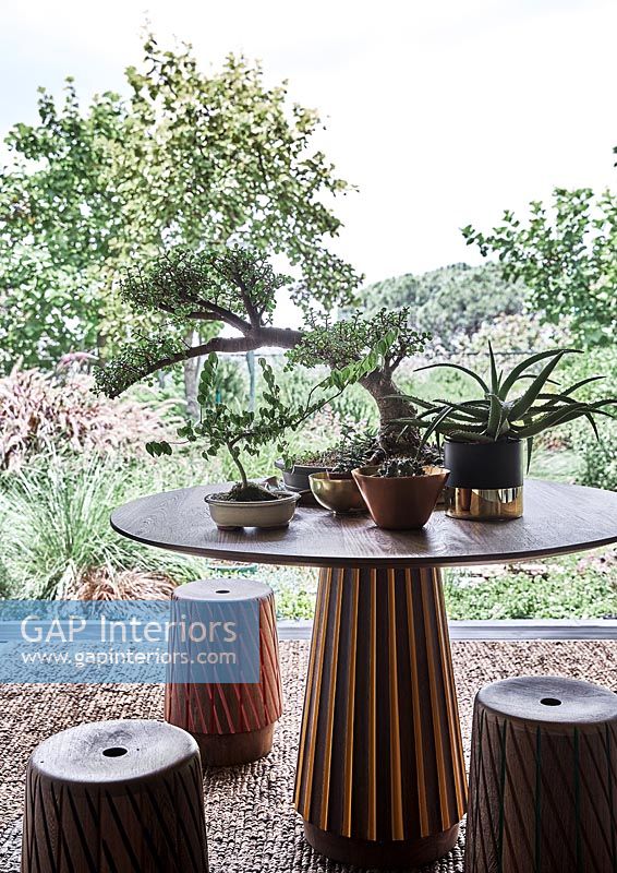Ornate table and matching stools - house plants on table with view to garden 