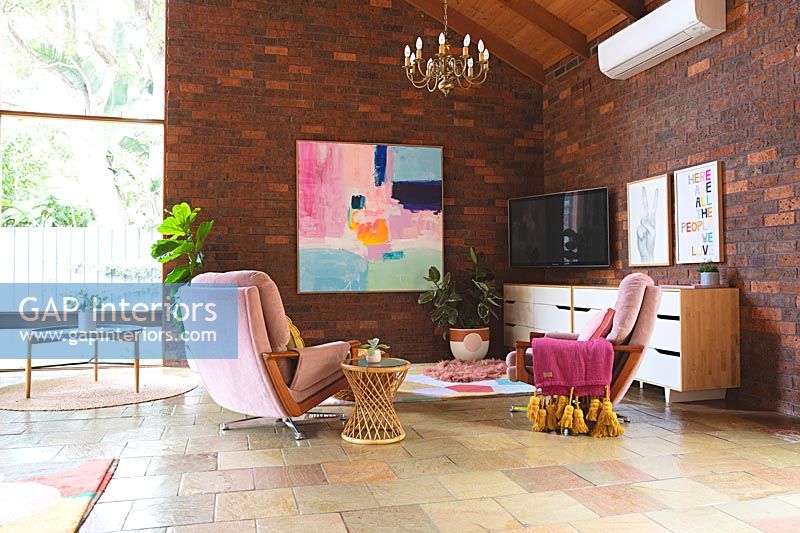 Large modern living room with exposed brick walls and stone flooring 
