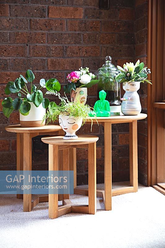 Nest of wooden tables with potted houseplants 
