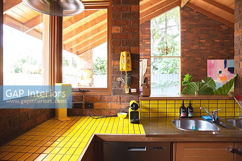 Yellow tiling in wooden kitchen 